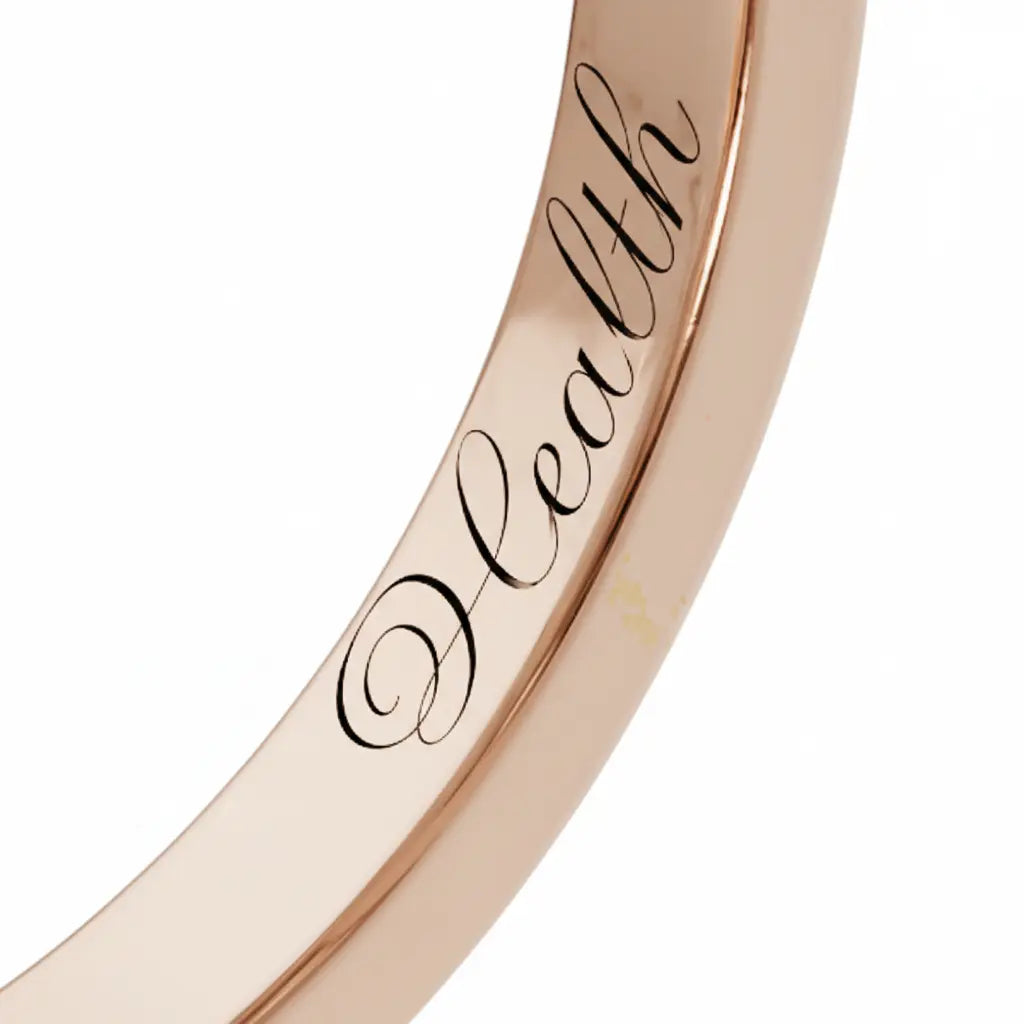Close-up of inner engraving on a Dimis Designs 18K rose gold square ring with hand-engraved words