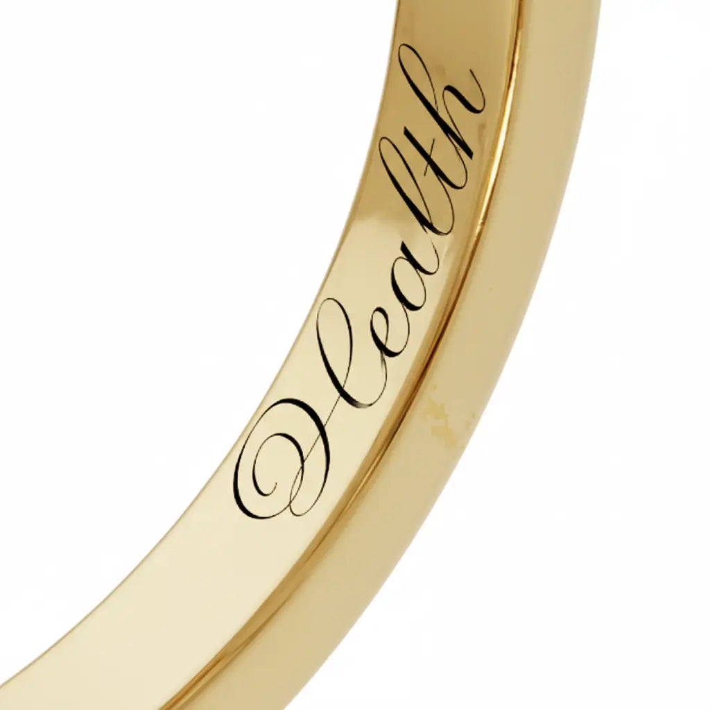 Close-up of inner engraving on a Dimis Designs 18K yellow gold square ring with hand-engraved words