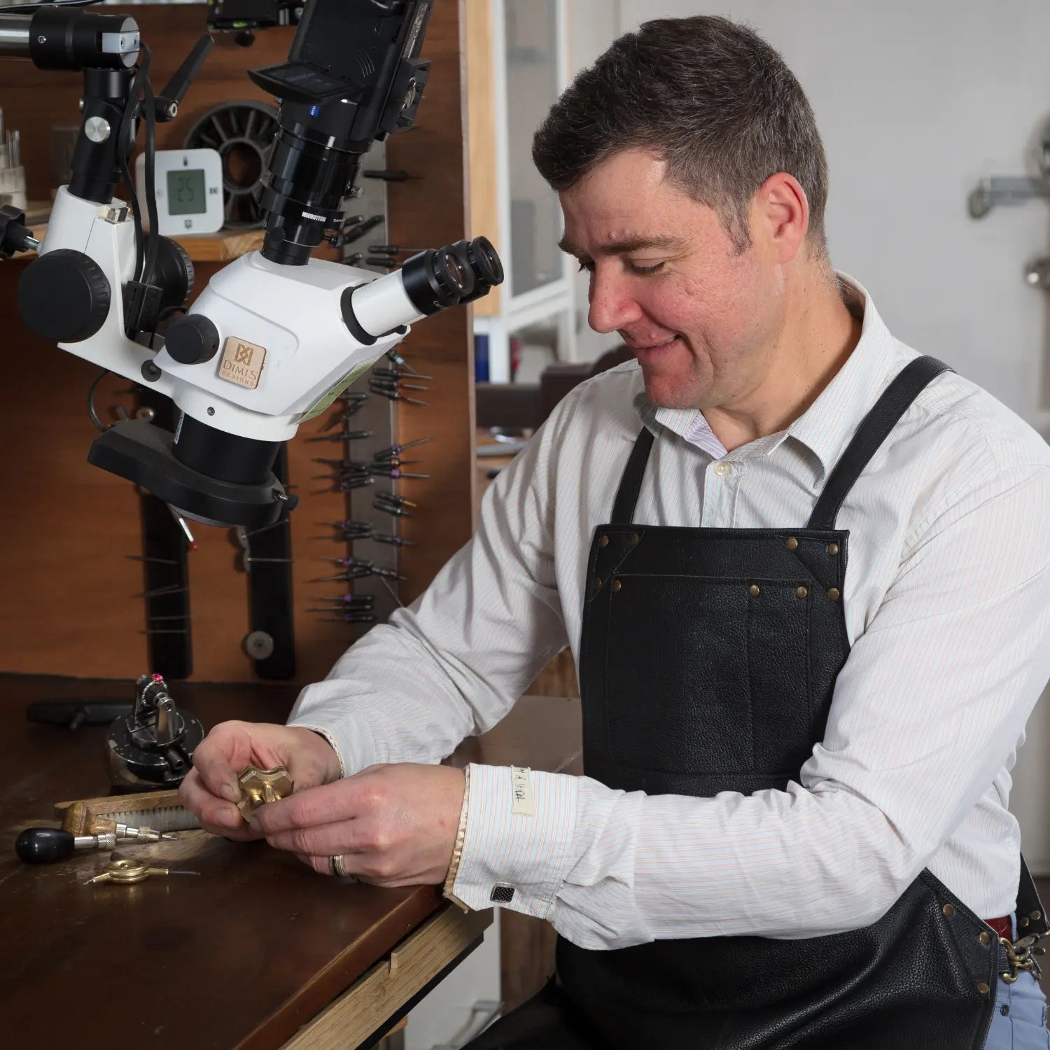 Master jeweller at Dimis Designs handcrafting a solid gold ring under a microscope in a Brisbane studio, showcasing precision, heritage craftsmanship, and intentional fine jewellery.